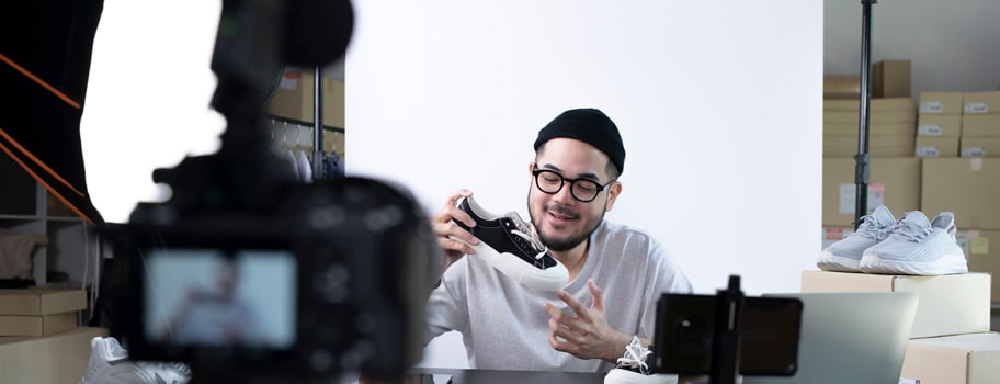 Nuori mies kameran edessä esittelemässä tuotetta.